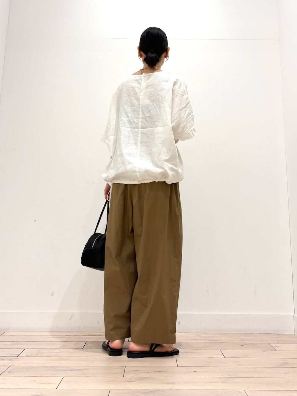 ベージュ系のその他パンツ、ブラック系のボストンバッグ、ブラック系のサンダルを着用したレディースの夏コーディネートの4枚目の写真