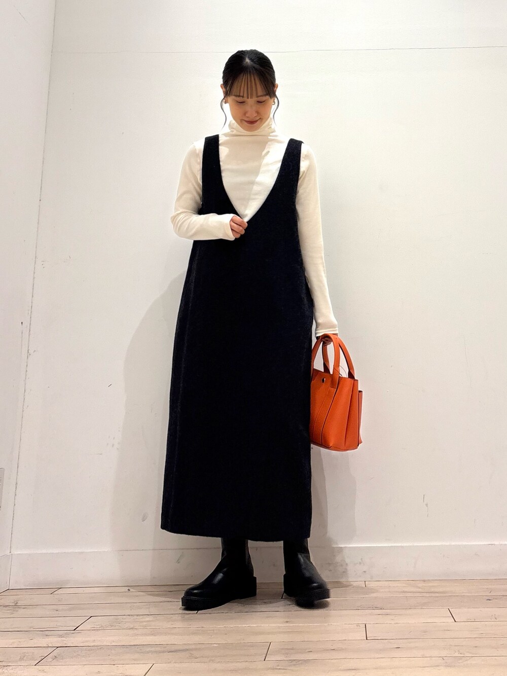 ブラック系のブーツ、オレンジ系のトートバッグ、グレー系のワンピースを着用したレディースの秋コーディネートの5枚目の写真