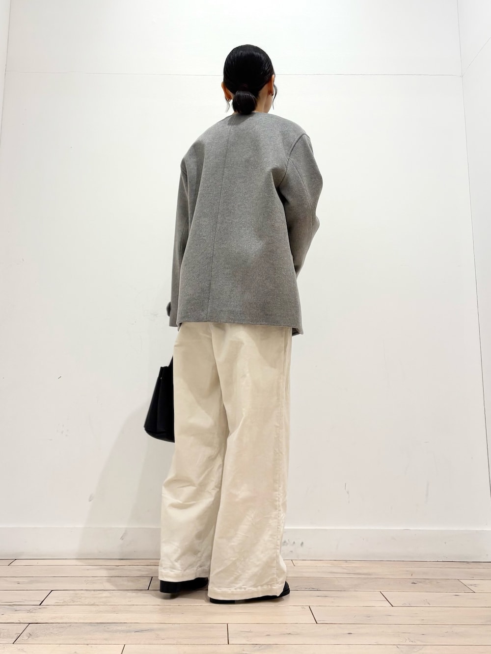 グレー系のピーコート、グレー系のニット/セーター、ブラック系のブーツを着用したレディースの冬コーディネートの4枚目の写真