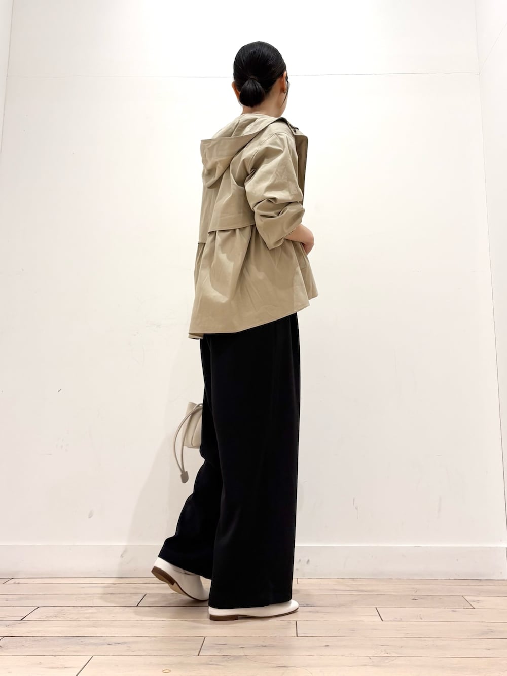 ベージュ系のその他アウター、ブラック系のその他パンツ、ホワイト系のショルダーバッグを着用したレディースの春コーディネートの3枚目の写真