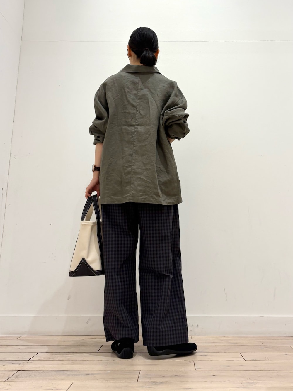 ホワイト系のタンクトップ、グレー系のカバーオール、グレー系のトートバッグを着用したレディースの春コーディネートの6枚目の写真