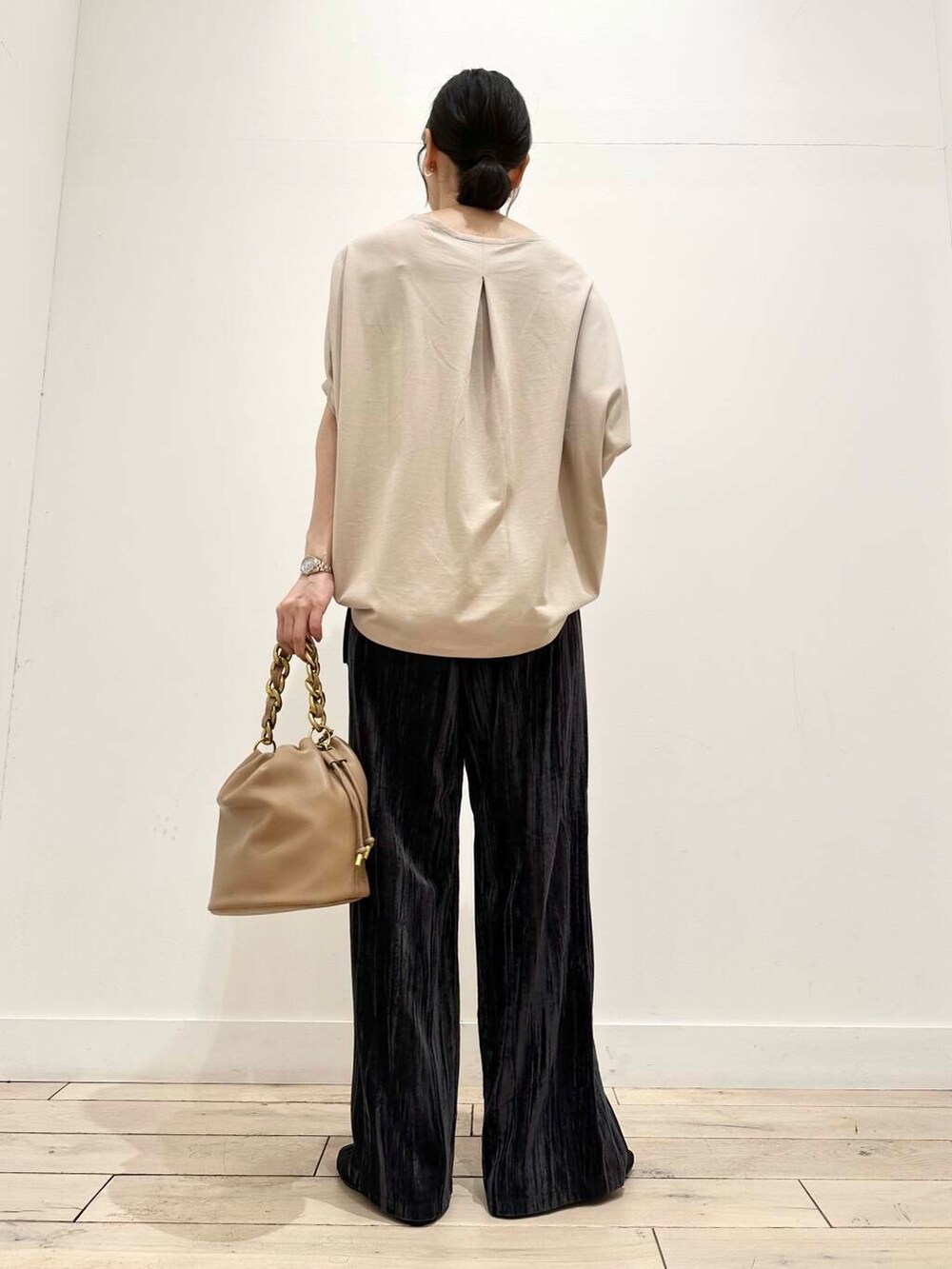 ブラウン系のショルダーバッグ、ブラック系のバレエシューズ、ベージュ系のTシャツ/カットソーを着用したレディースの夏コーディネートの3枚目の写真