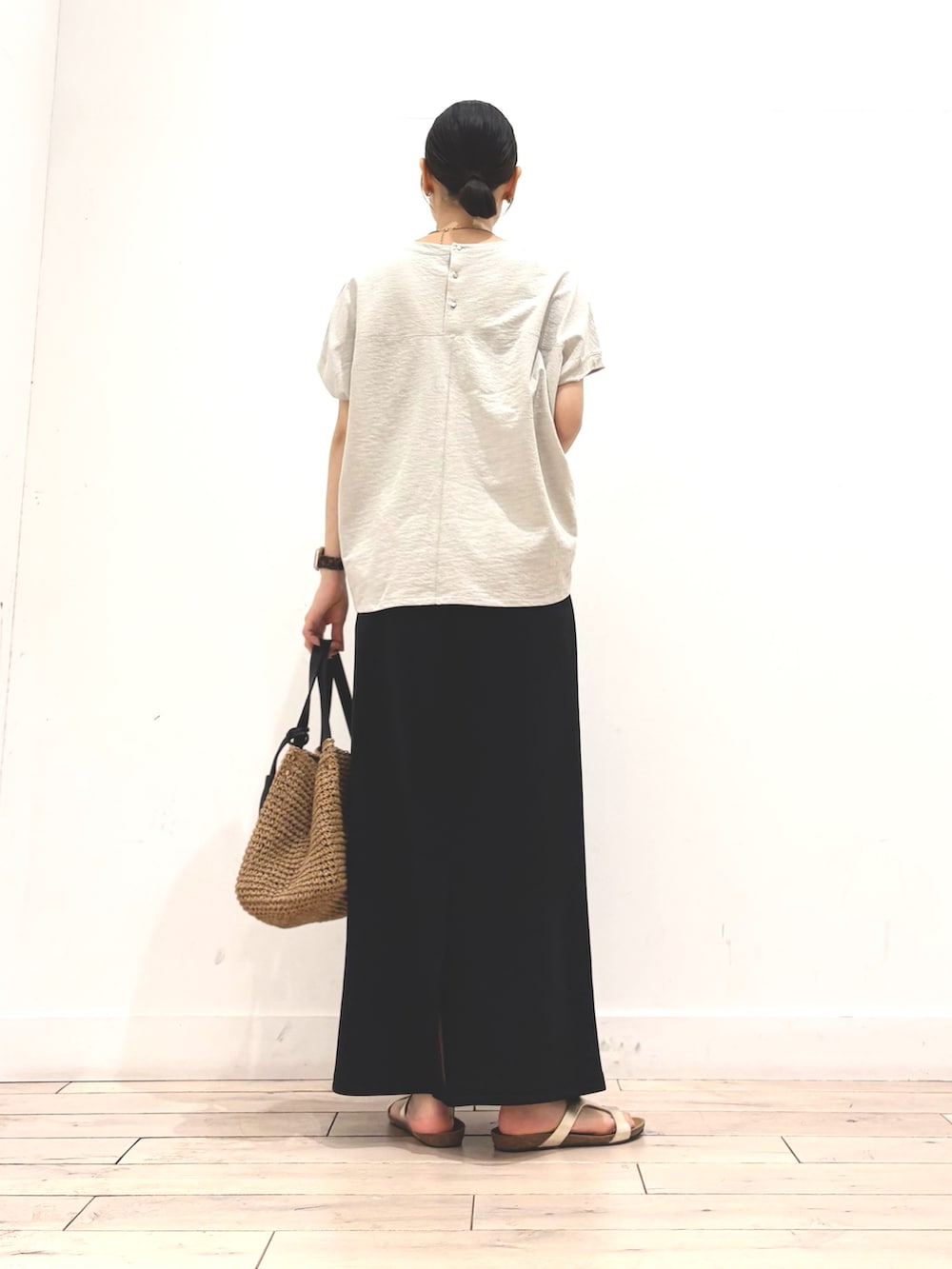 グレー系のTシャツ/カットソー、ブラック系のスカート、イエロー系のかごバッグを着用したレディースの夏コーディネートの4枚目の写真