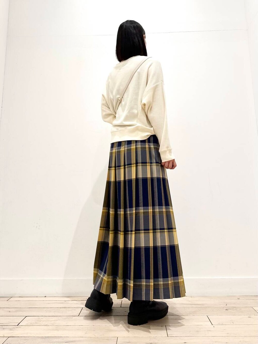 ベージュ系のTシャツ/カットソー、ブラック系のブーツ、ブルー系のスカートを着用したレディースの秋コーディネートの3枚目の写真