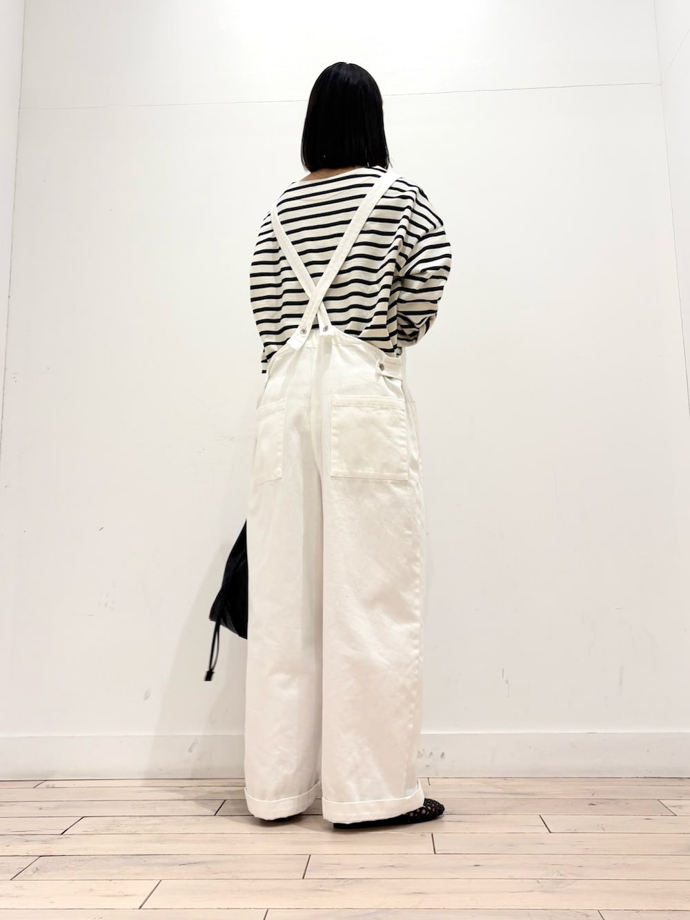 ホワイト系のTシャツ/カットソー、ホワイト系のサロペット/オーバーオール、ブラック系のショルダーバッグを着用したレディースの春コーディネートの3枚目の写真