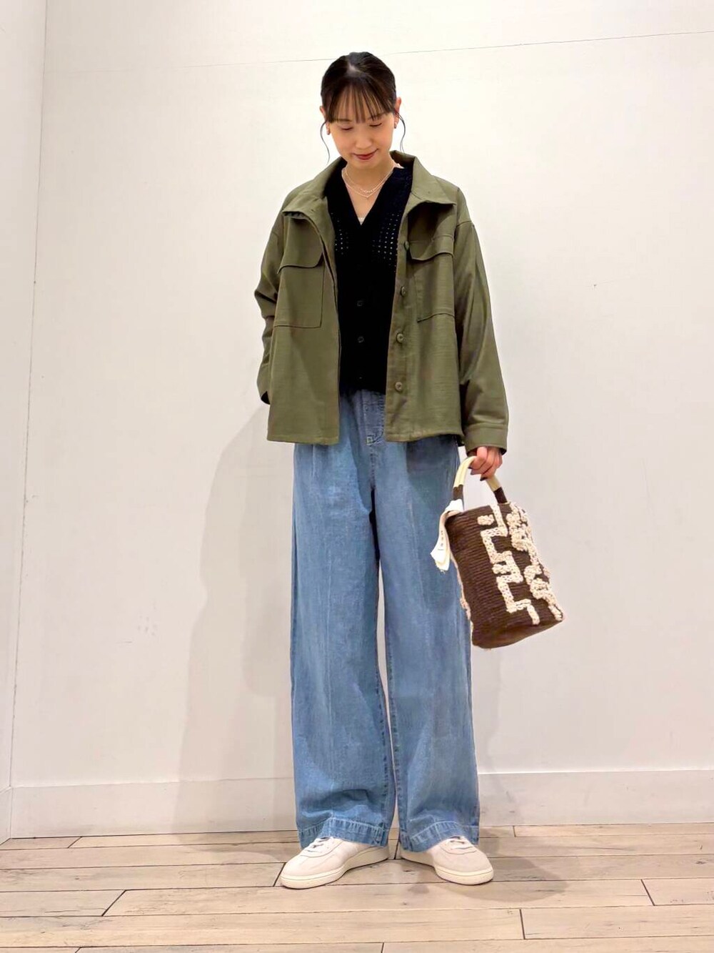 グリーン系のミリタリージャケット、ブルー系のデニムパンツ、ブルー系のカーディガン/ボレロを着用したレディースの春コーディネートの5枚目の写真