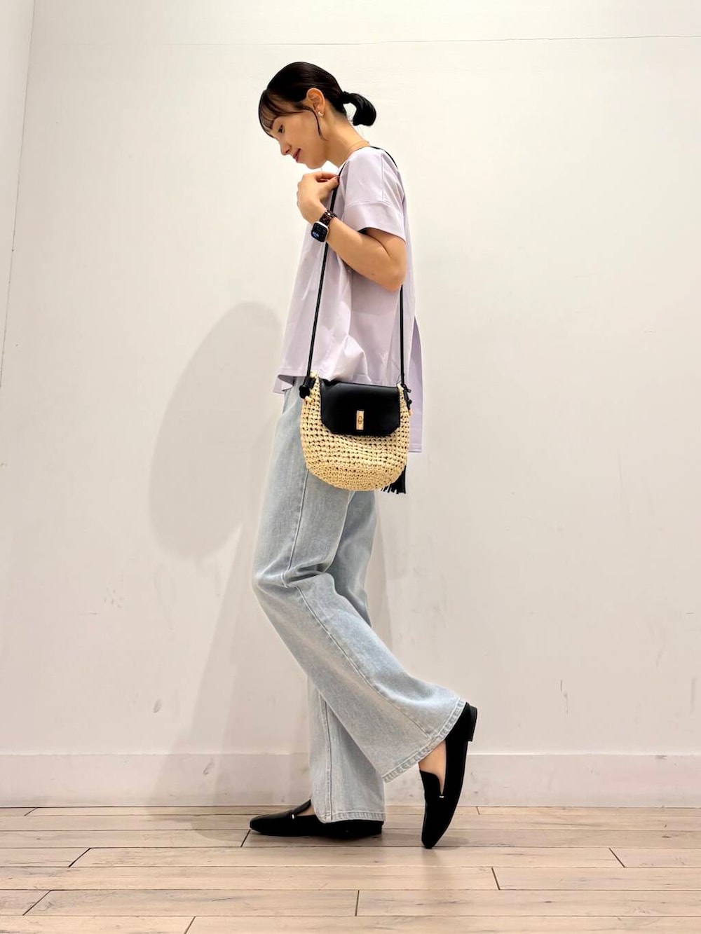 ブラック系のローファー、ベージュ系のショルダーバッグ、ブルー系のデニムパンツを着用したレディースの夏コーディネートの3枚目の写真