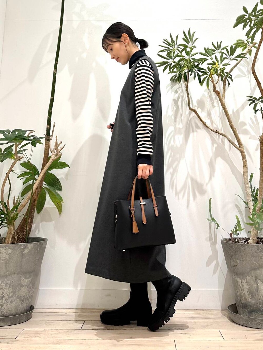 ブラック系のトートバッグ、ブラック系のTシャツ/カットソー、グレー系のワンピースを着用したレディースの秋コーディネートの3枚目の写真