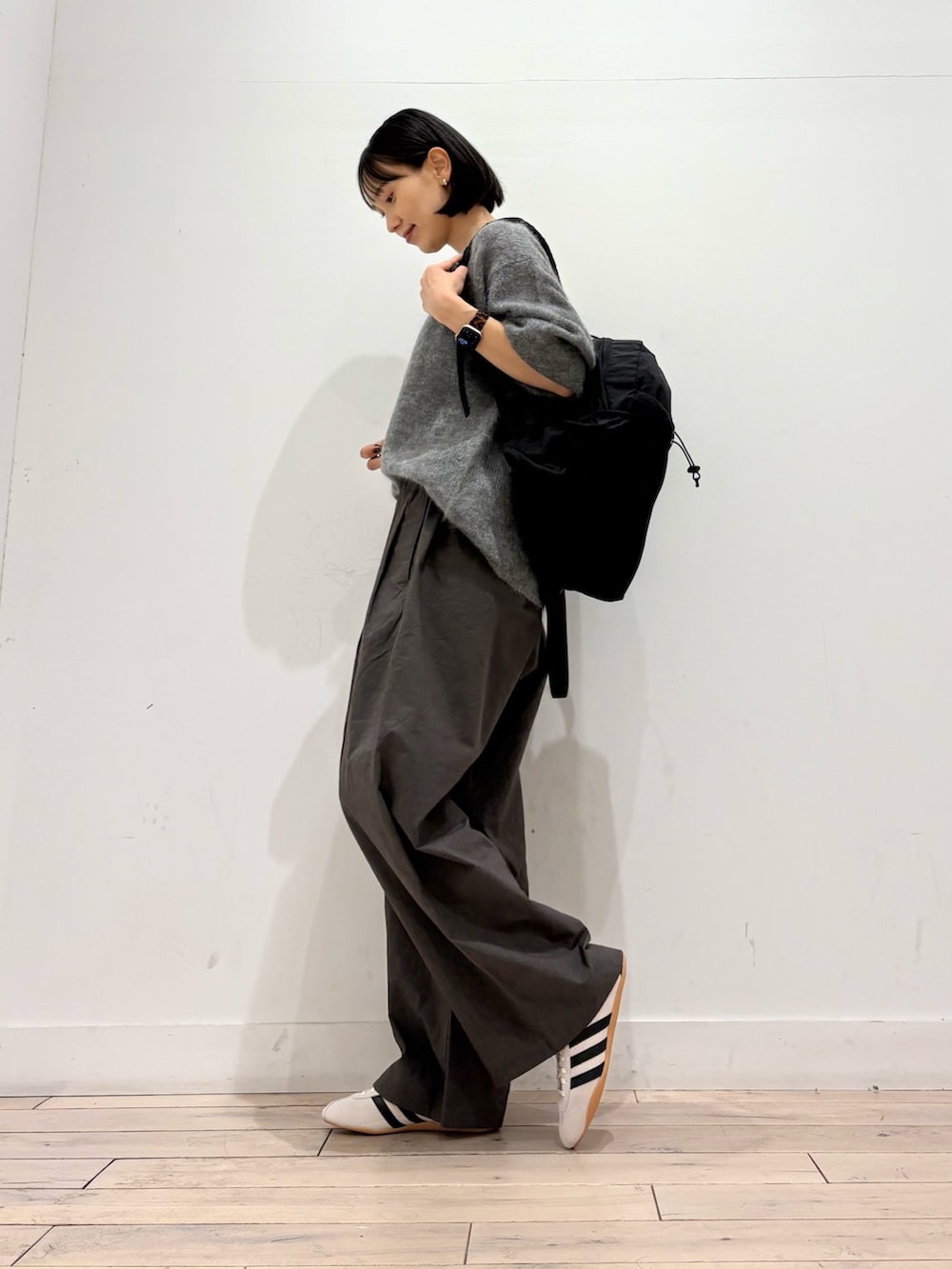 グレー系のニット/セーター、グレー系のその他パンツ、ホワイト系のスニーカーを着用したレディースの秋コーディネートの3枚目の写真