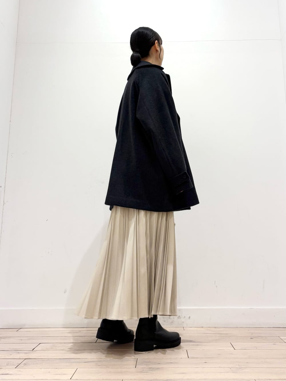 ホワイト系のTシャツ/カットソー、グレー系のピーコート、ブラック系のブーツを着用したレディースの冬コーディネートの3枚目の写真