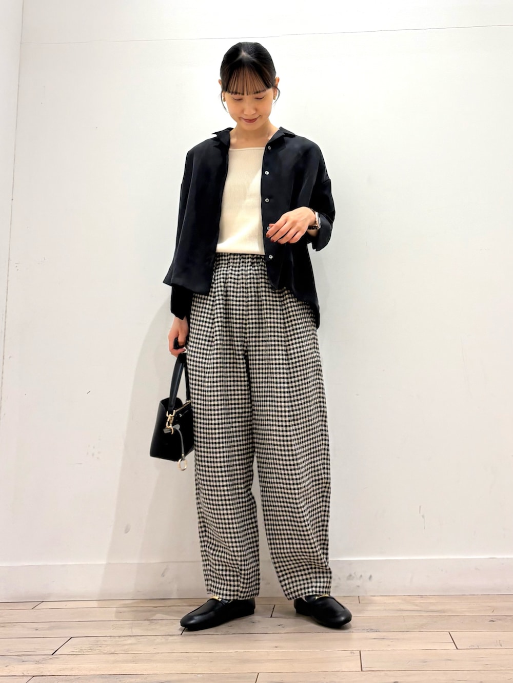 ホワイト系のタンクトップ、ブラック系のシャツ/ブラウス、ブラック系のショルダーバッグを着用したレディースの春コーディネートの2枚目の写真