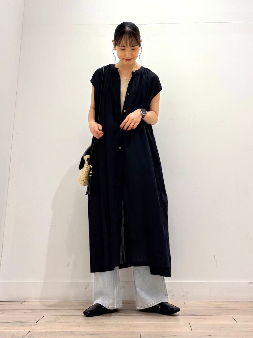 ブラック系のローファー、ベージュ系のショルダーバッグ、ブルー系のデニムパンツを着用したレディースの夏コーディネートの2枚目の写真