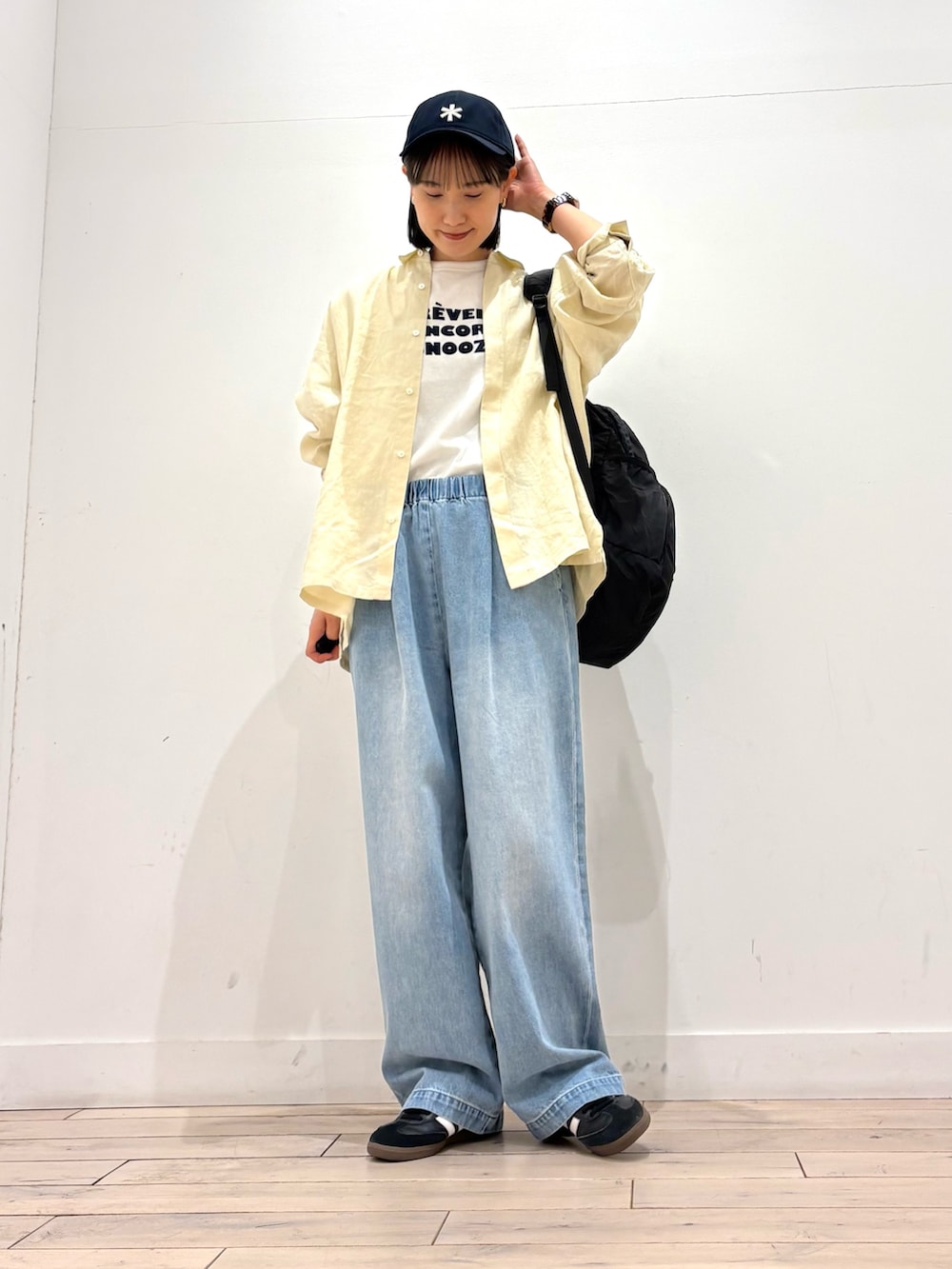 ブルー系のデニムパンツ、ブラック系のスニーカー、ブラック系のバックパック/リュックを着用したレディースの春コーディネートの2枚目の写真