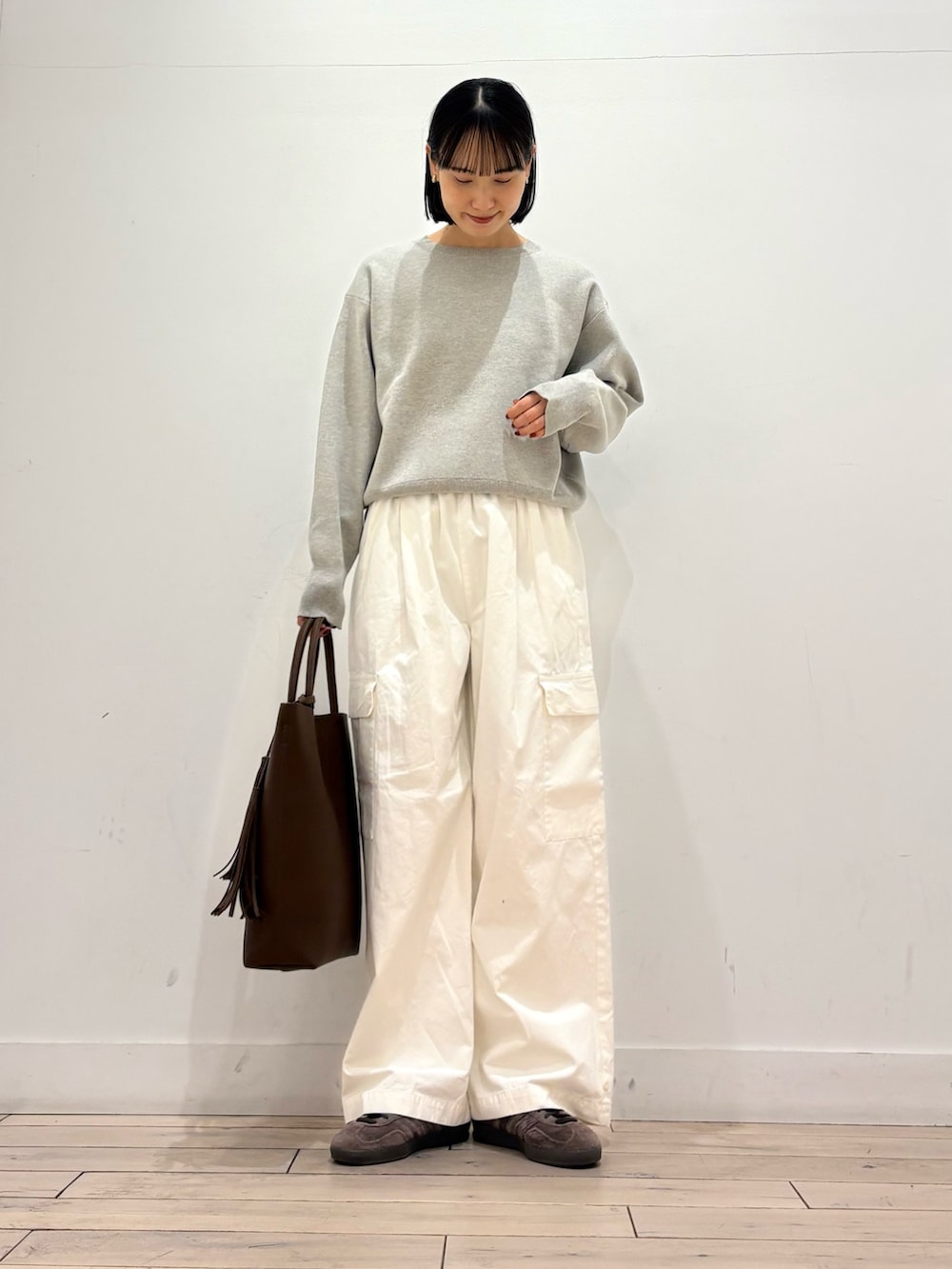 ベージュ系のニット/セーター、ベージュ系のトレンチコート、ブラウン系のトートバッグを着用したレディースの冬コーディネートの4枚目の写真