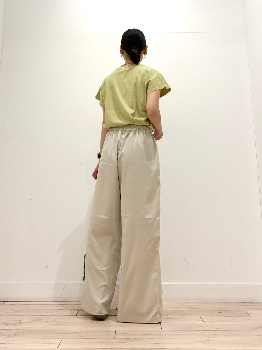 グリーン系のTシャツ/カットソー、ホワイト系のその他パンツ、ブラック系のサンダルを着用したレディースの夏コーディネートの4枚目の写真