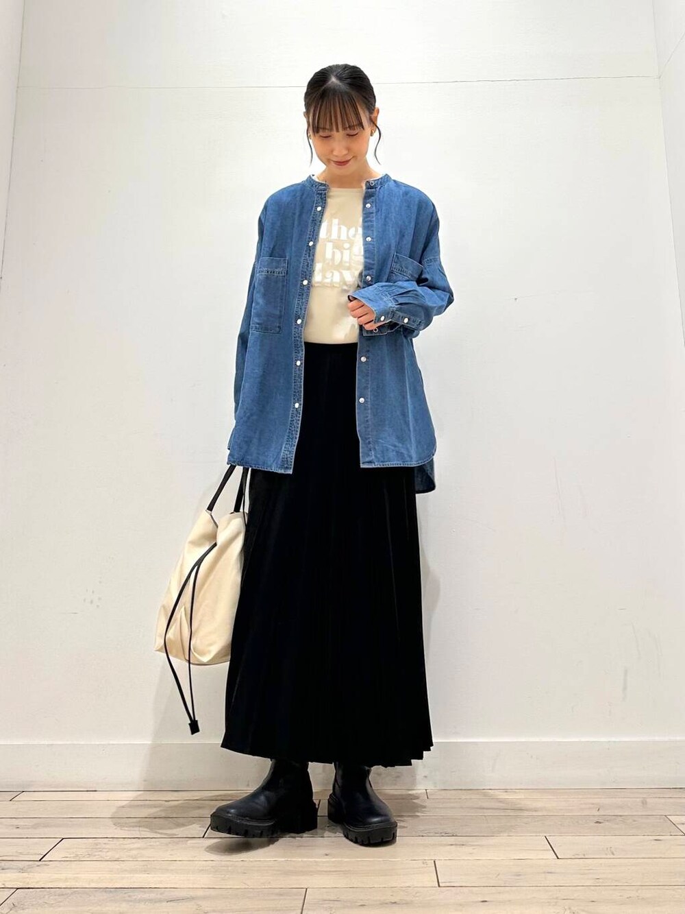 ホワイト系のトートバッグ、ブラック系のブーツ、ベージュ系のTシャツ/カットソーを着用したレディースの冬コーディネートの2枚目の写真