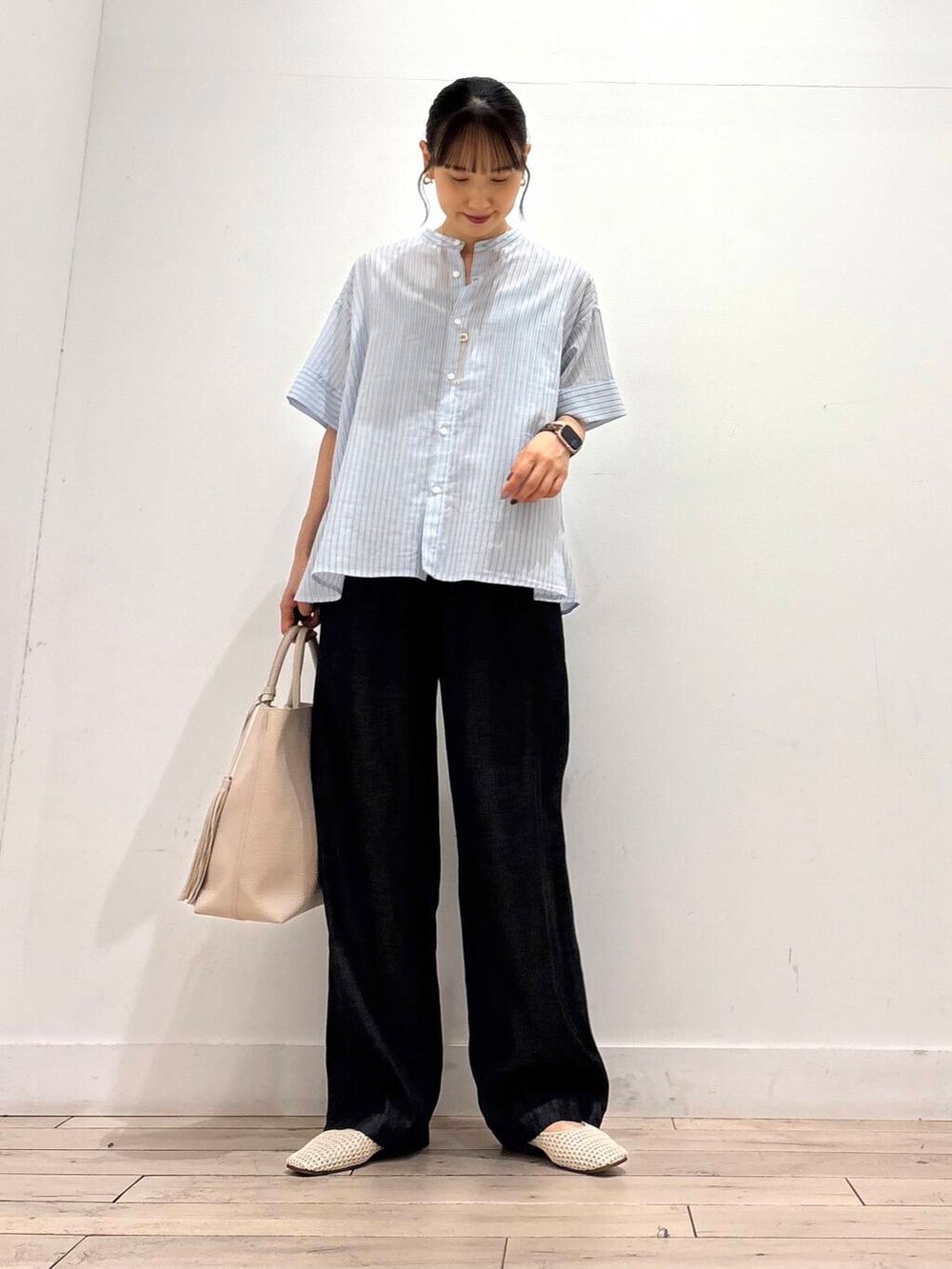 ホワイト系のトートバッグ、ホワイト系のバレエシューズ、ブラック系のデニムパンツを着用したレディースの夏コーディネートの2枚目の写真