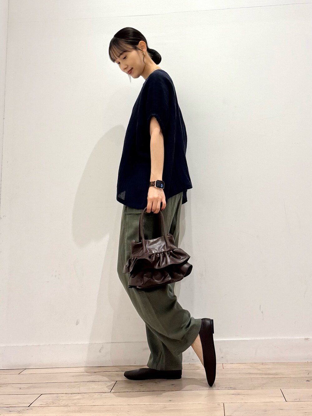 グリーン系のその他パンツ、ブラウン系のパンプス、ブラウン系のハンドバッグを着用したレディースの夏コーディネートの3枚目の写真