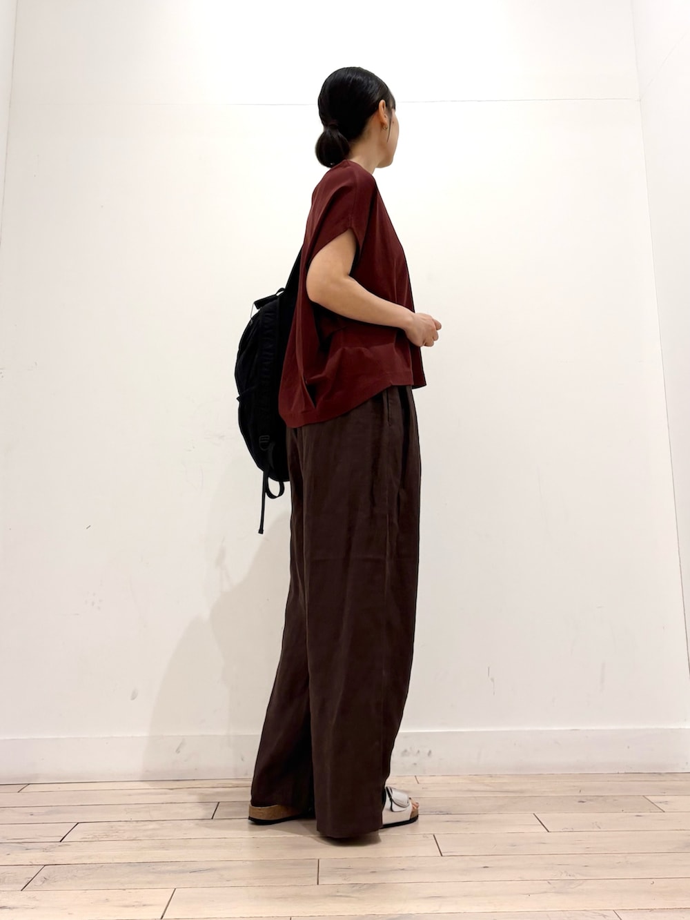 ブラウン系のその他パンツ、ブラック系のバックパック/リュック、シルバー系のサンダルを着用したレディースの夏コーディネートの4枚目の写真