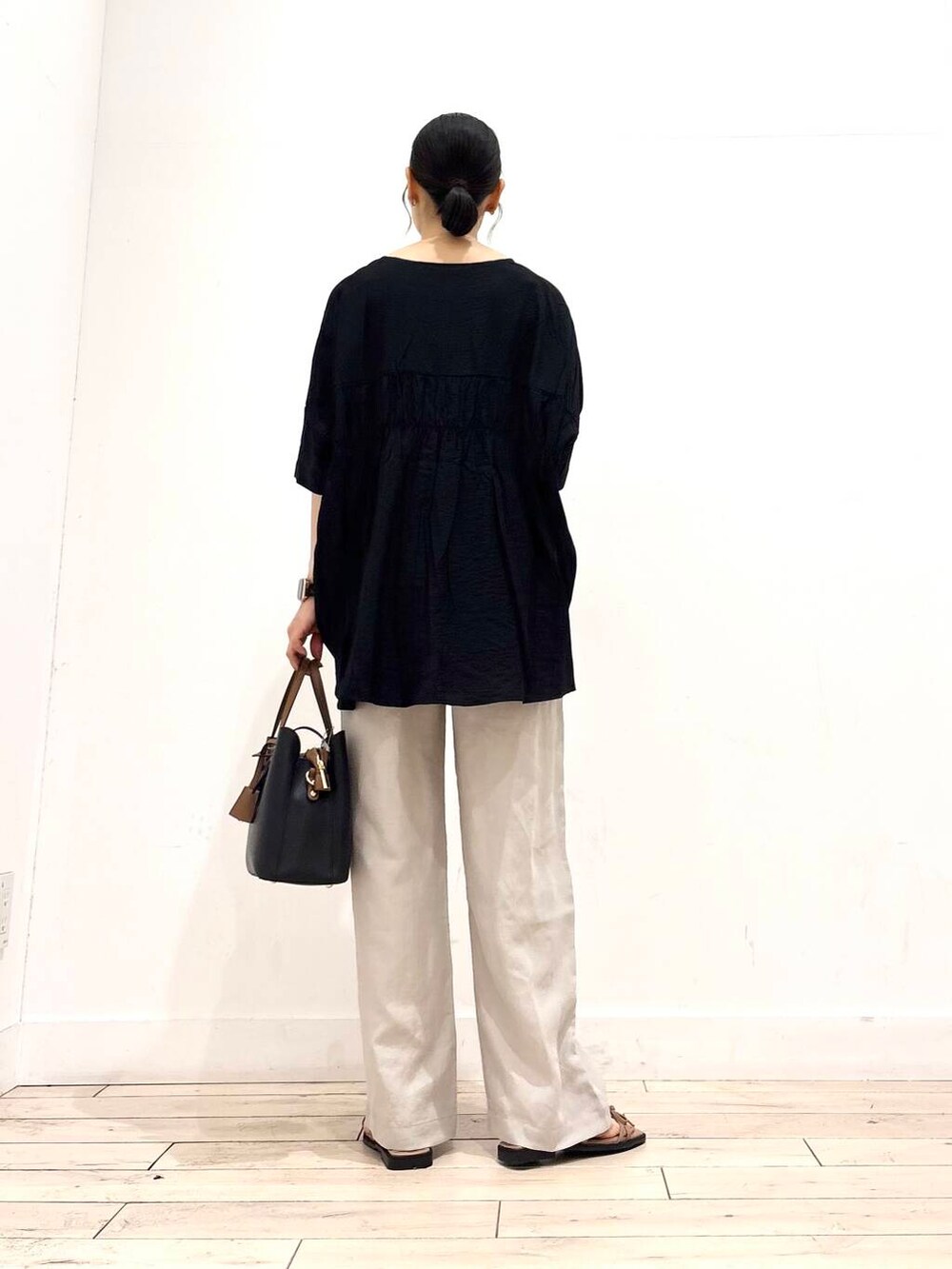 ブラック系のトートバッグ、ブラック系のシャツ/ブラウス、ベージュ系のその他パンツを着用したレディースの夏コーディネートの5枚目の写真