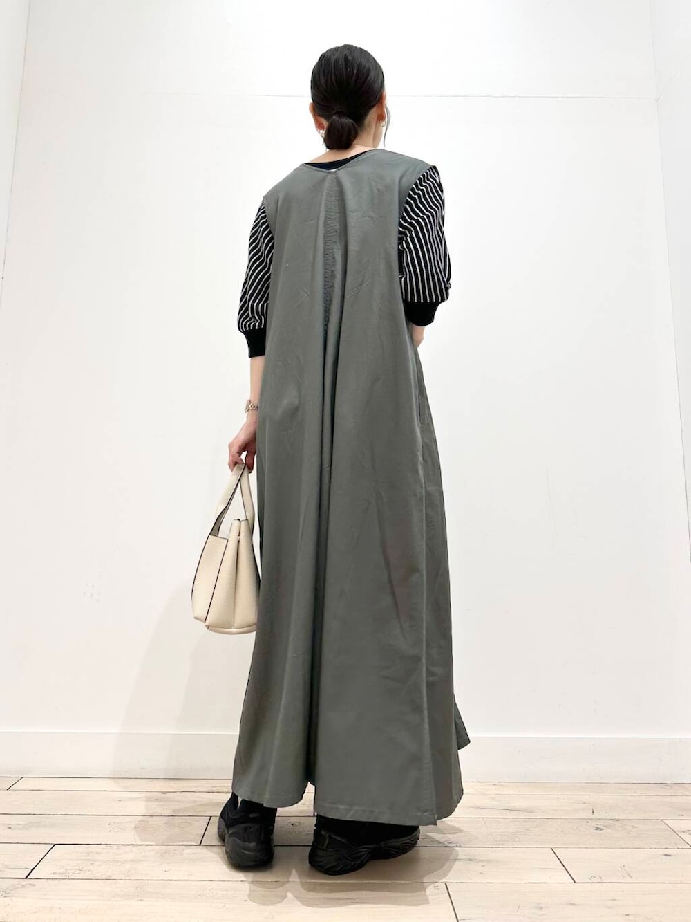 ホワイト系のトートバッグ、ブラック系のスニーカー、ブラック系のTシャツ/カットソーを着用したレディースの夏コーディネートの3枚目の写真