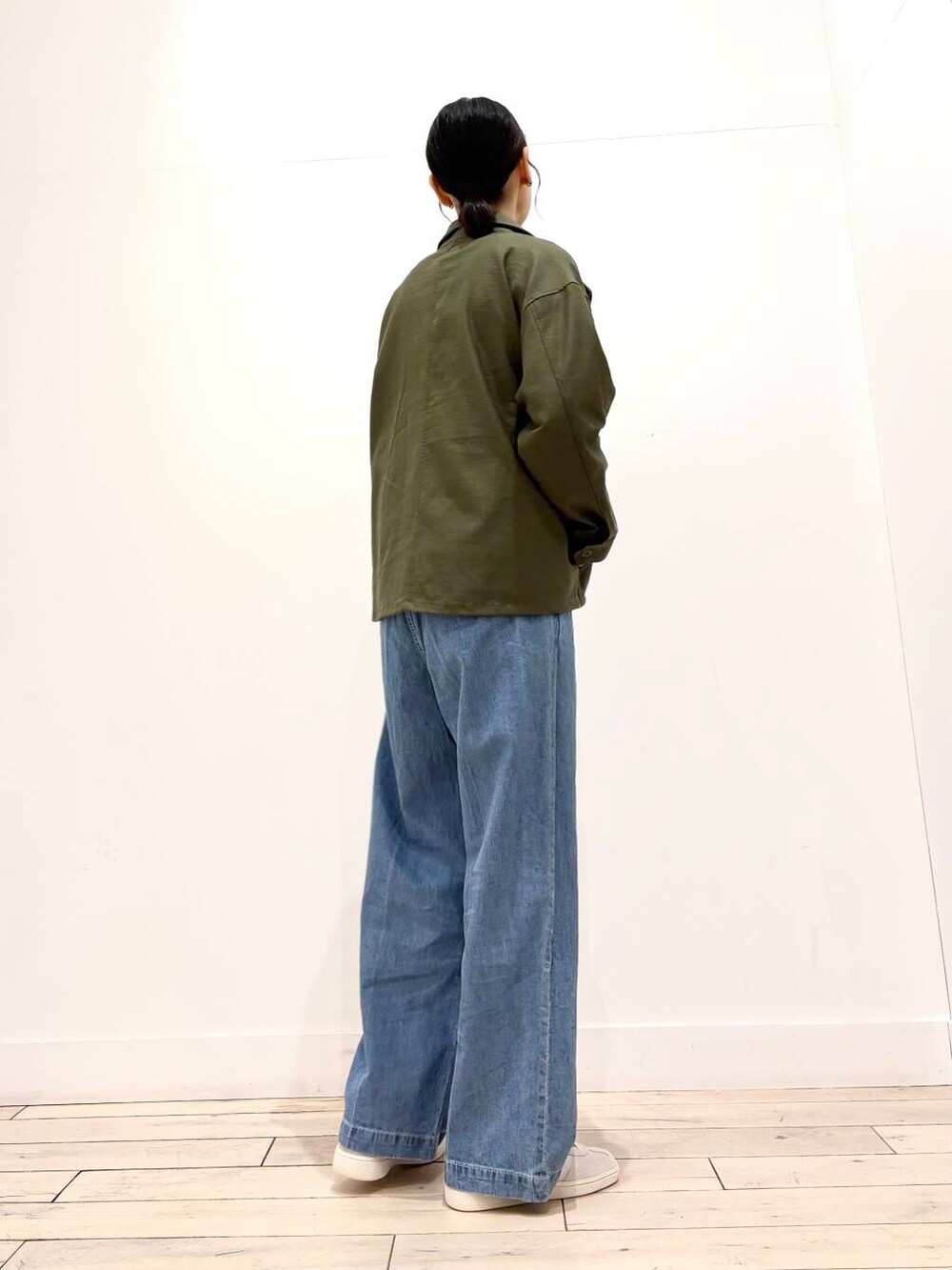 グリーン系のミリタリージャケット、ブルー系のデニムパンツ、ブルー系のカーディガン/ボレロを着用したレディースの春コーディネートの7枚目の写真