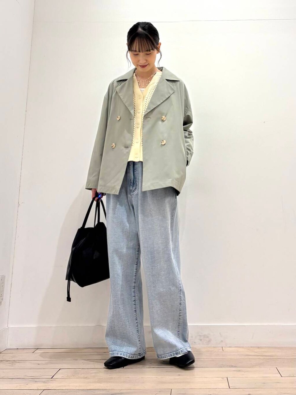 ブルー系のデニムパンツ、グリーン系のその他アウター、ブラック系のパンプスを着用したレディースの春コーディネートの5枚目の写真