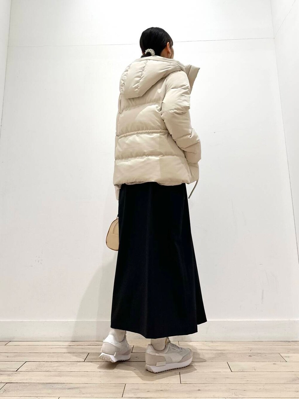 ブラウン系のニット/セーター、ホワイト系のダウンジャケット/コート、イエロー系のボストンバッグを着用したレディースの冬コーディネートの6枚目の写真