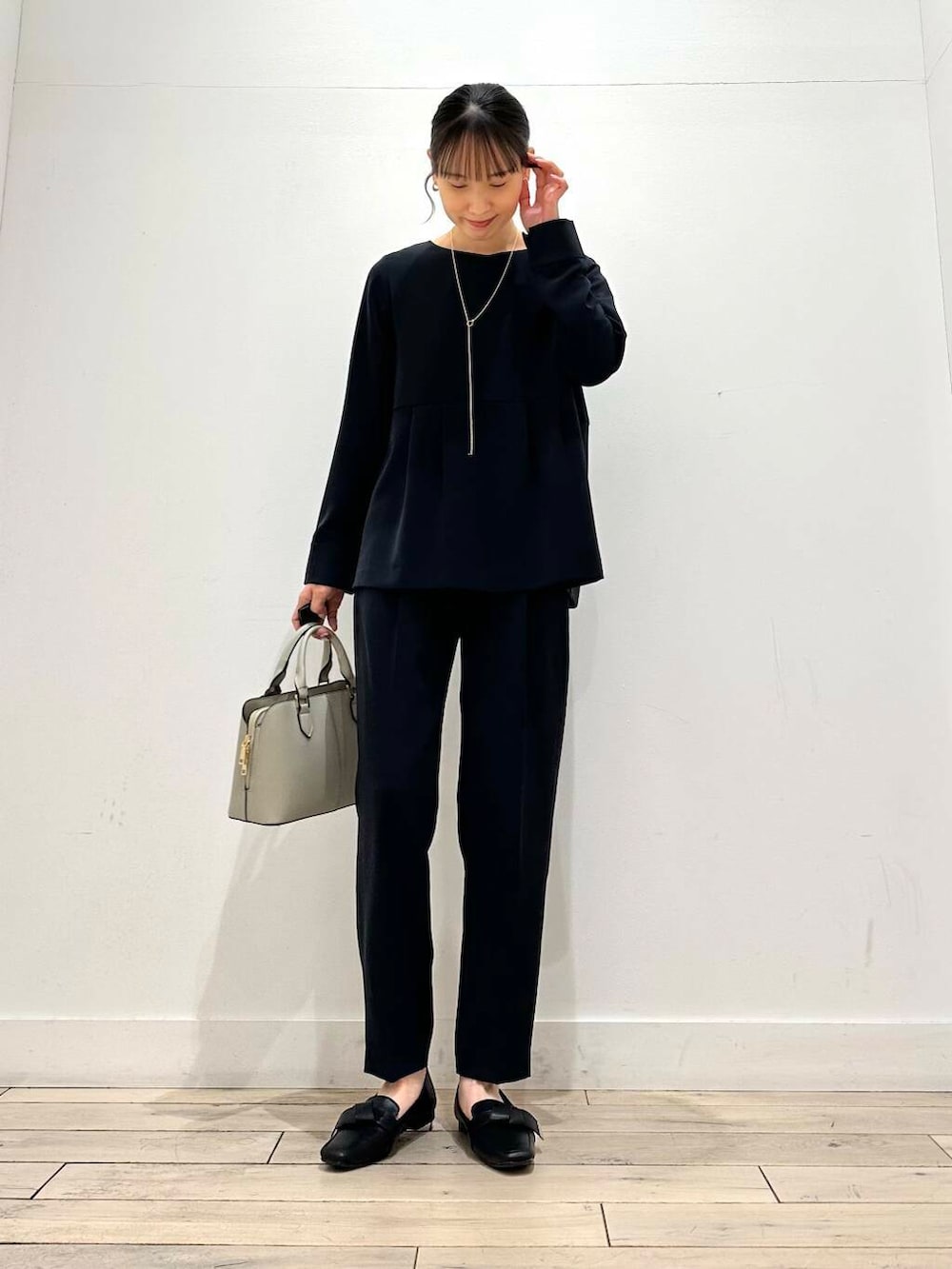 ブラック系のドレスシューズ、グレー系のハンドバッグ、ブルー系のセットアップを着用したレディースの冬コーディネートの3枚目の写真