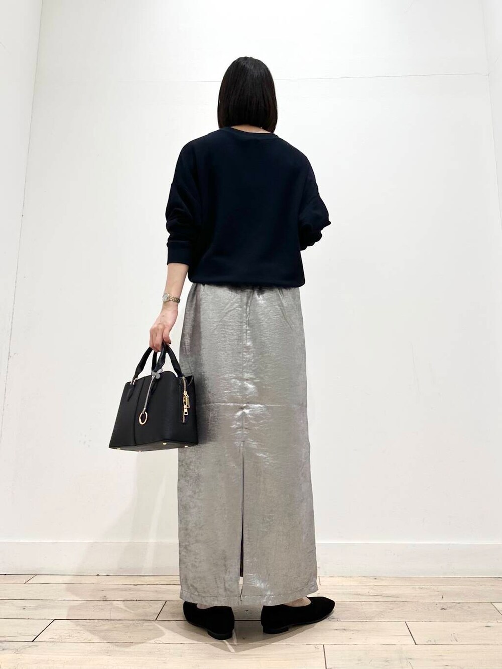 ブルー系のTシャツ/カットソー、ブラック系のハンドバッグ、ブラック系のバレエシューズを着用したレディースの秋コーディネートの4枚目の写真