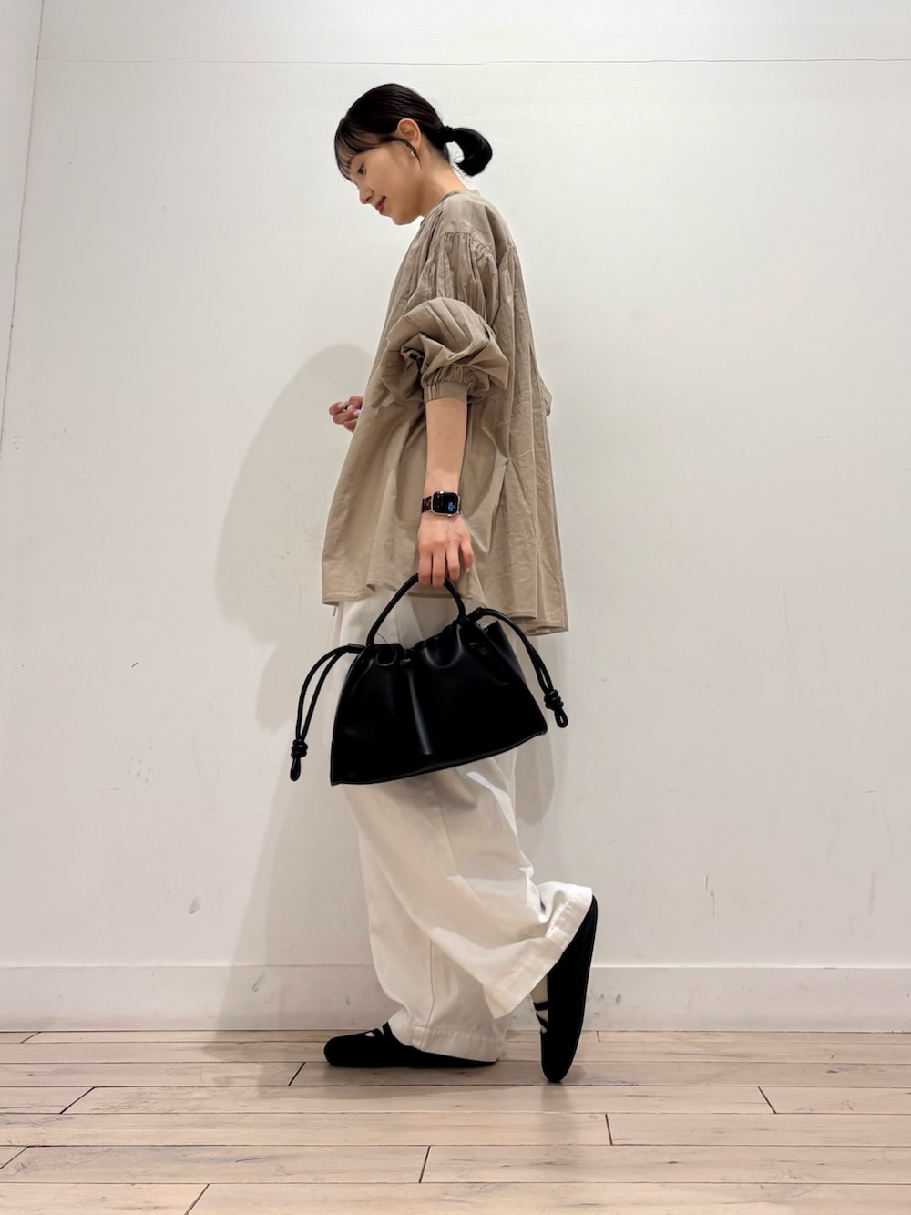 ホワイト系のタンクトップ、ベージュ系のシャツ/ブラウス、ブラック系のトートバッグを着用したレディースの春コーディネートの3枚目の写真