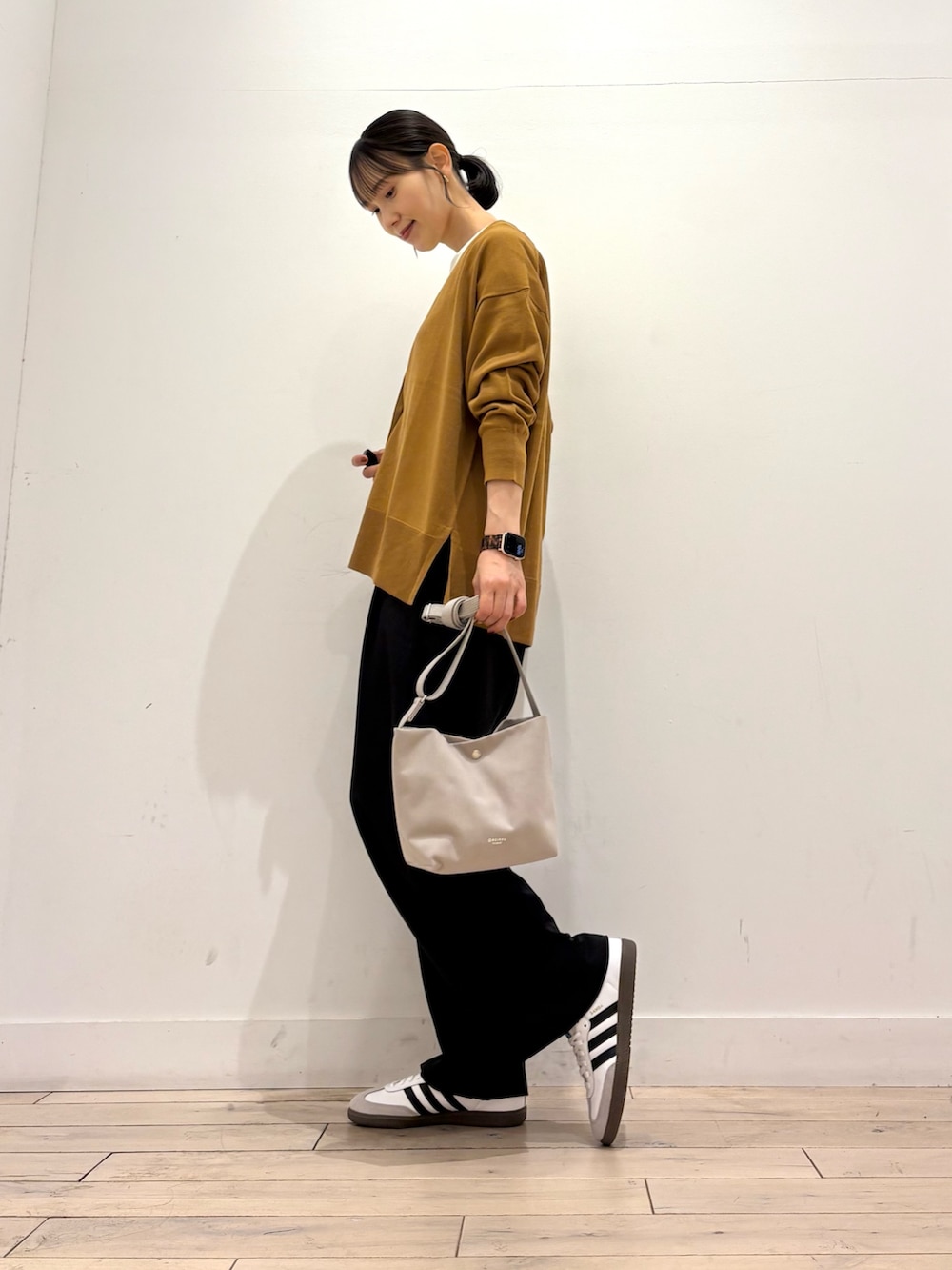 ゴールド系のカーディガン/ボレロ、ホワイト系のTシャツ/カットソー、ホワイト系のスニーカーを着用したレディースの秋コーディネートの4枚目の写真