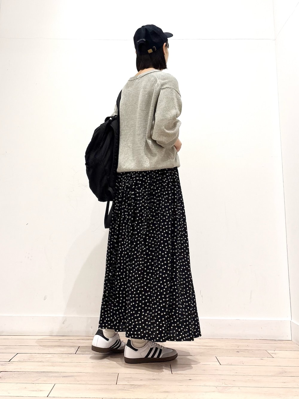 グレー系のニット/セーター、ブラック系のスカート、ブラック系のバックパック/リュックを着用したレディースの冬コーディネートの4枚目の写真