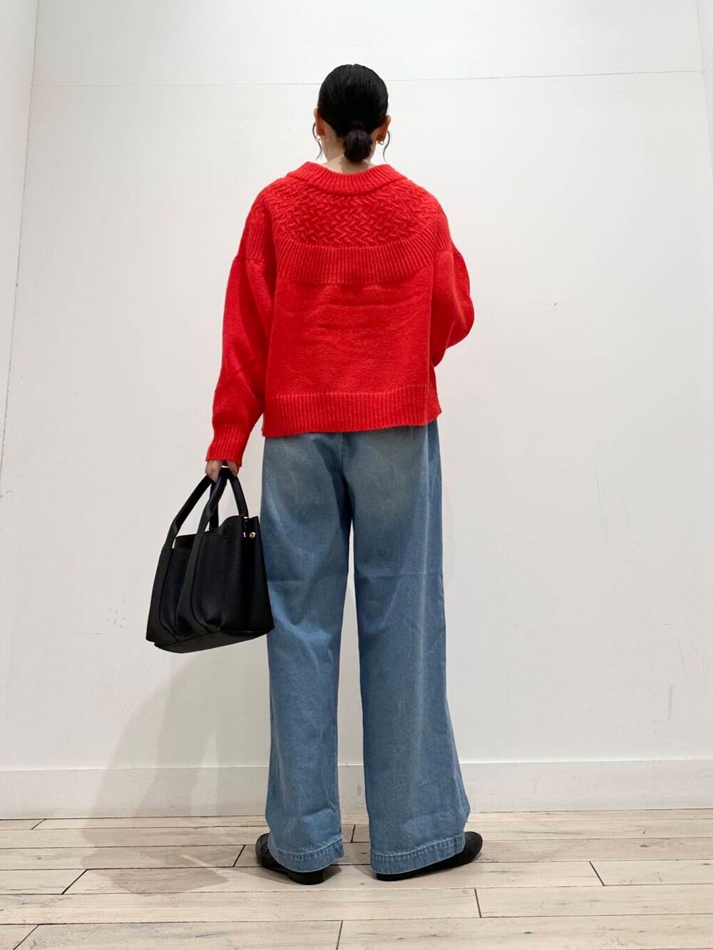 ブラック系のトートバッグ、グレー系のその他アウター、レッド系のニット/セーターを着用したレディースの冬コーディネートの4枚目の写真