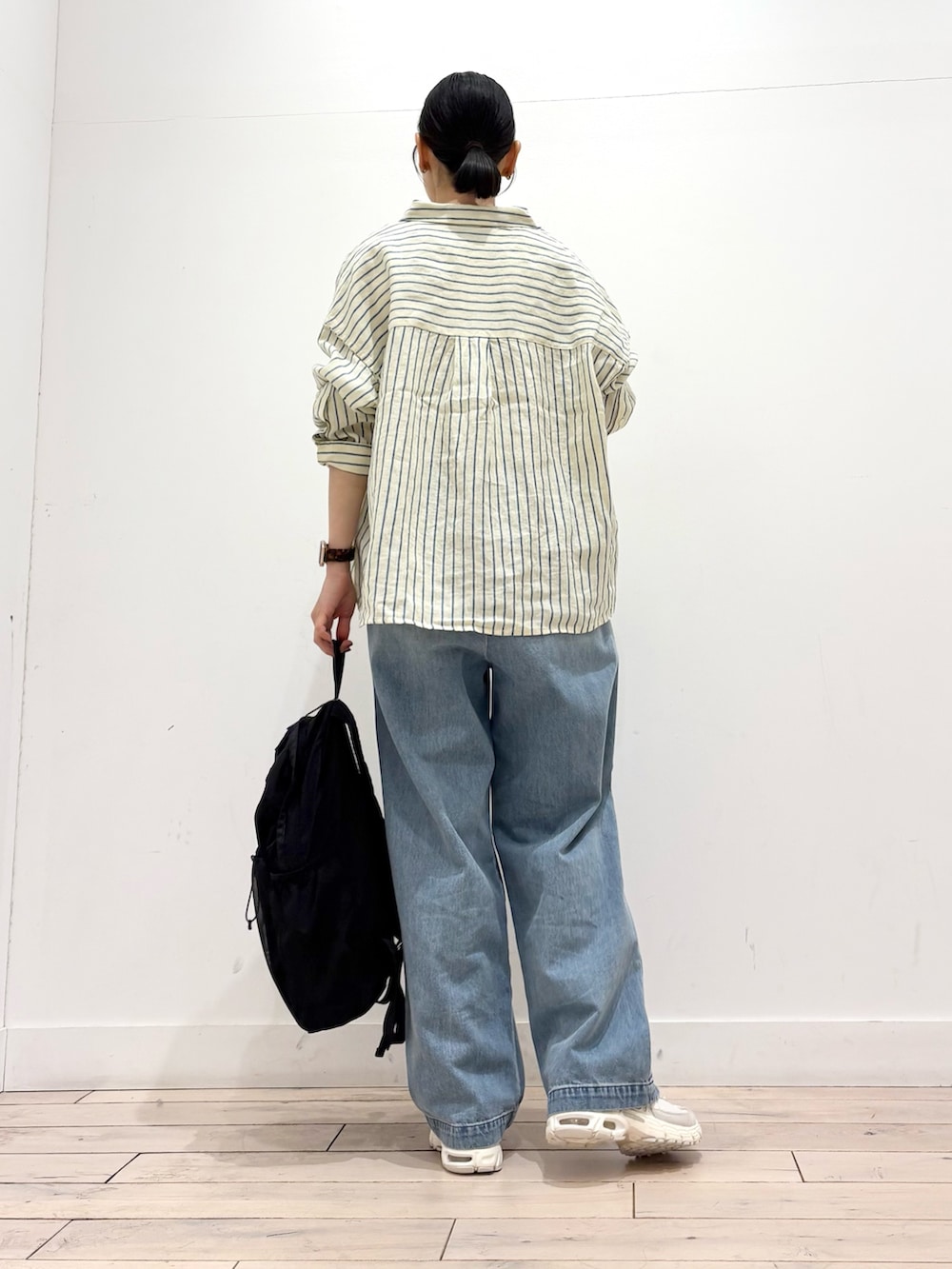 イエロー系のシャツ/ブラウス、ホワイト系のタンクトップ、ブルー系のデニムパンツを着用したレディースの春コーディネートの3枚目の写真