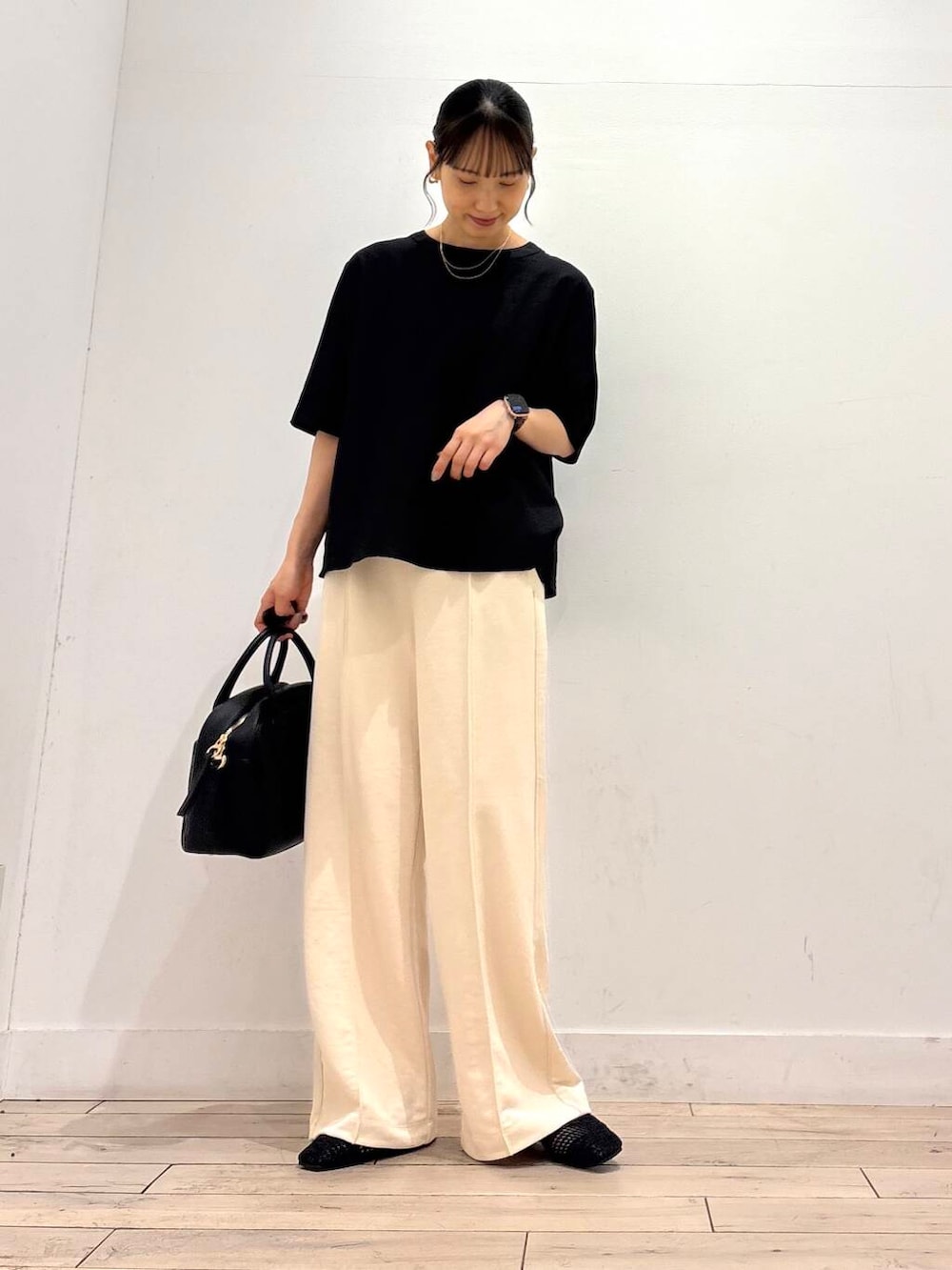 ブラック系のボストンバッグ、ブラック系のバレエシューズ、ブラック系のシャツ/ブラウスを着用したレディースの夏コーディネートの2枚目の写真