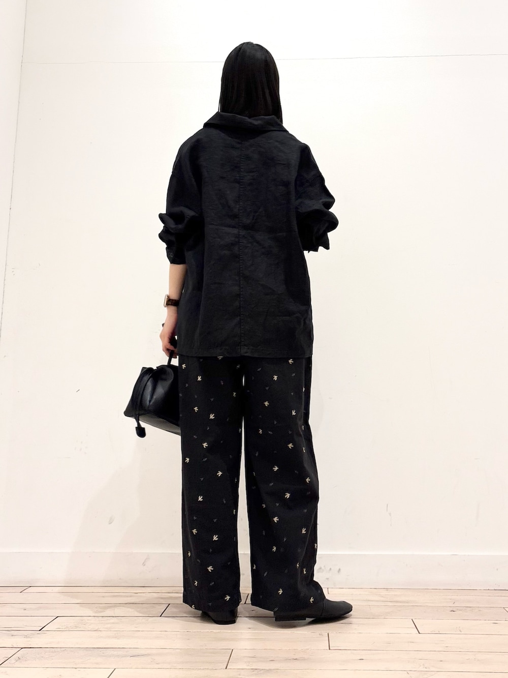 ホワイト系のタンクトップ、ブラック系のカバーオール、ブラック系のショルダーバッグを着用したレディースの春コーディネートの3枚目の写真