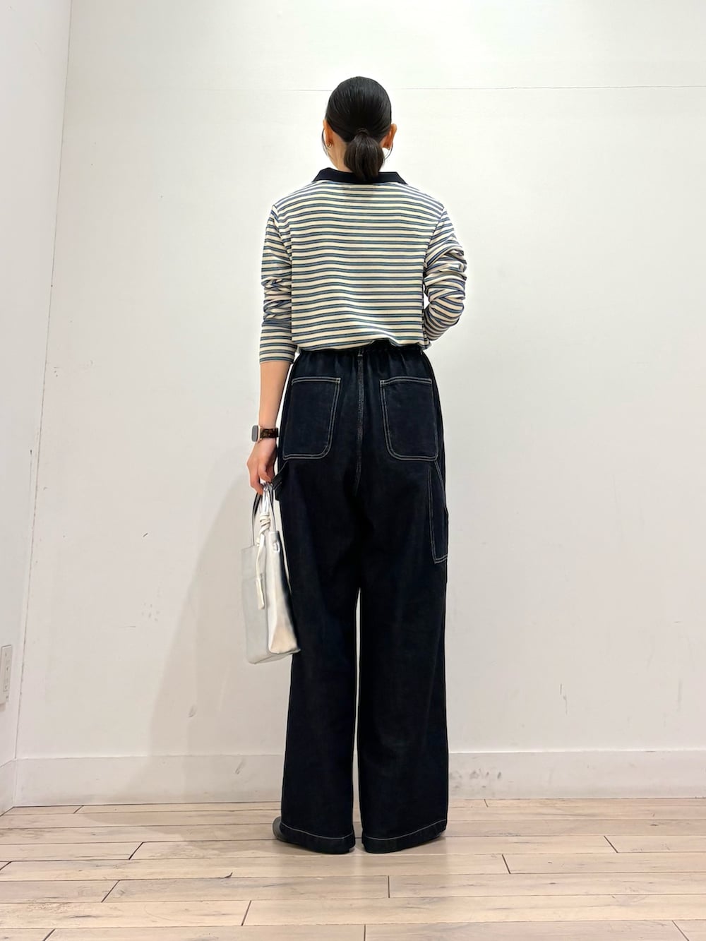 ホワイト系のポロシャツ、ブルー系のその他パンツ、シルバー系のトートバッグを着用したレディースの秋コーディネートの3枚目の写真