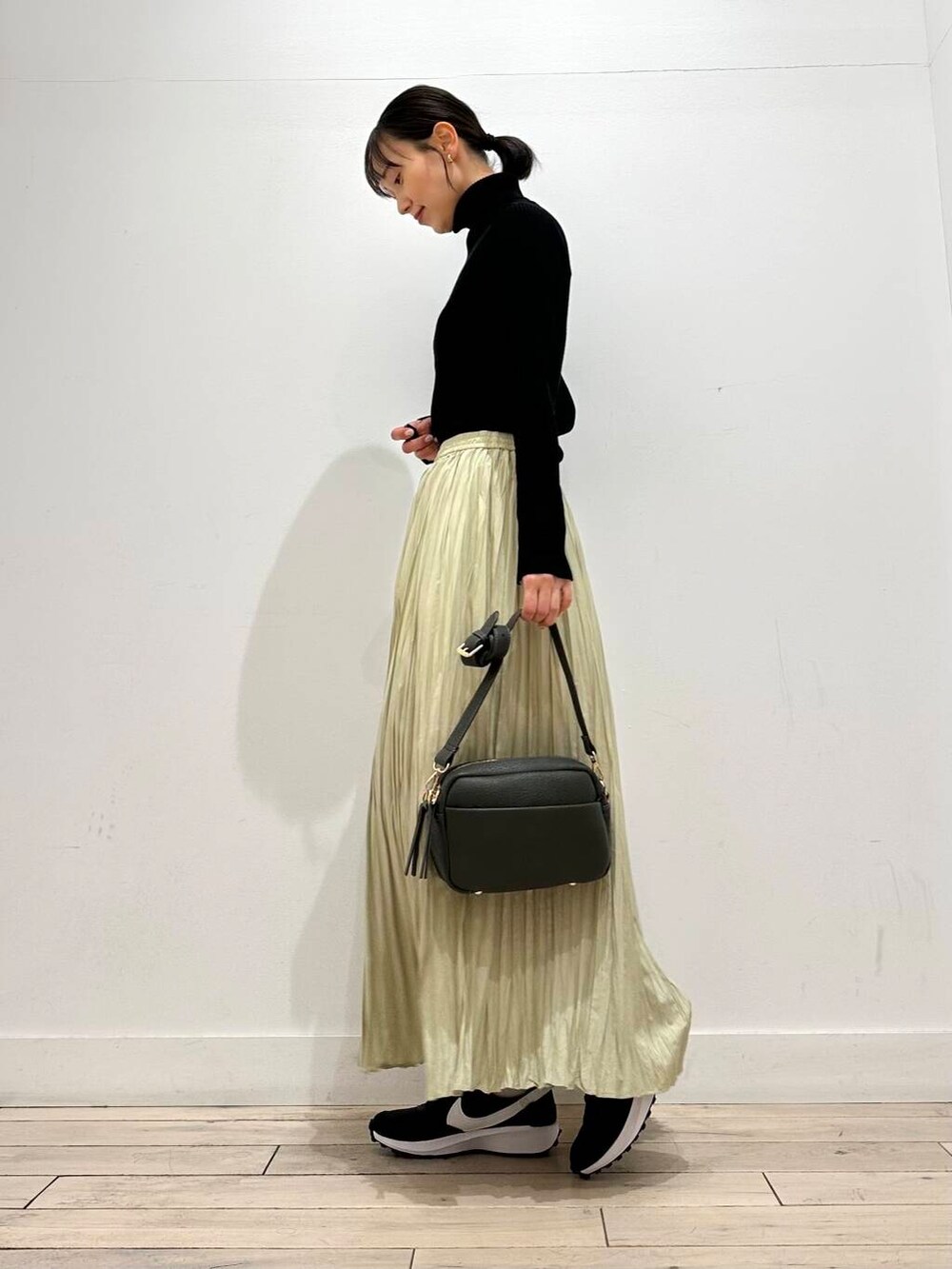 グリーン系のショルダーバッグ、ブラック系のその他アウター、ブラック系のニット/セーターを着用したレディースの冬コーディネートの4枚目の写真