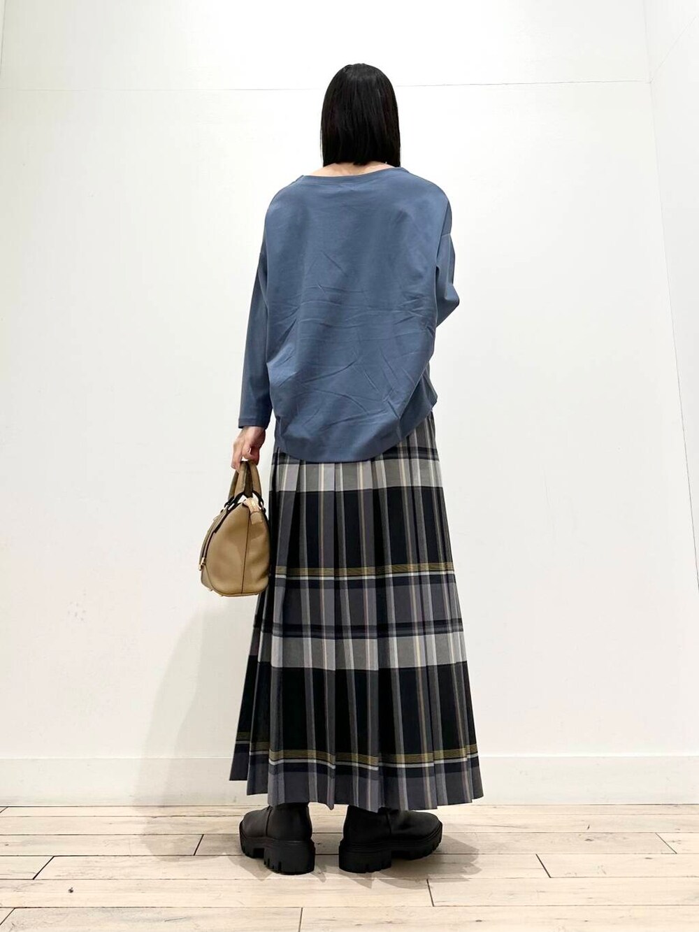 ブルー系のTシャツ/カットソー、ブラウン系のボストンバッグ、ブラック系のブーツを着用したレディースの秋コーディネートの4枚目の写真