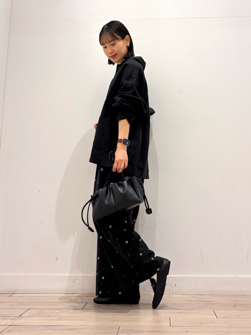 ホワイト系のタンクトップ、ブラック系のカバーオール、ブラック系のショルダーバッグを着用したレディースの春コーディネートの2枚目の写真