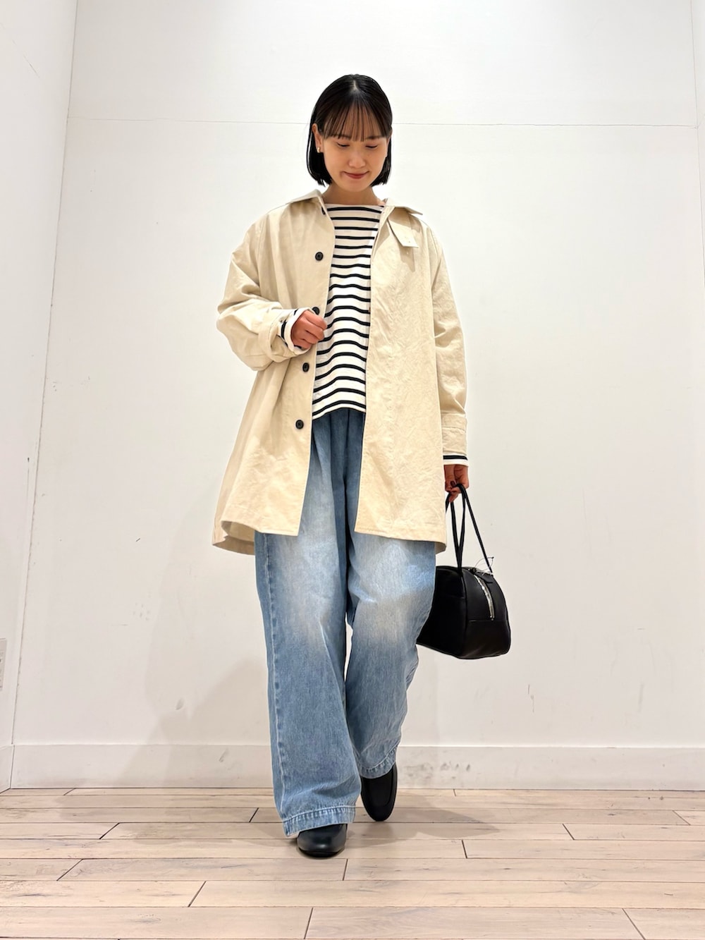 ブラック系のTシャツ/カットソー、ホワイト系のその他アウター、ブラック系のボストンバッグを着用したレディースの冬コーディネートの2枚目の写真