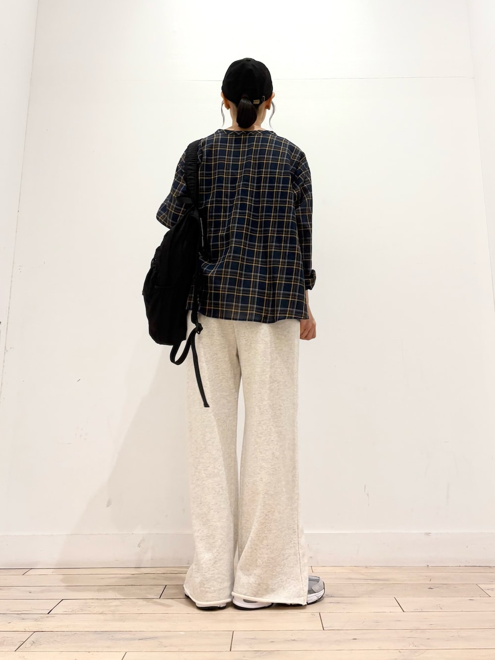 ベージュ系のその他パンツ、ブラック系のバックパック/リュック、グレー系のスニーカーを着用したレディースの秋コーディネートの4枚目の写真