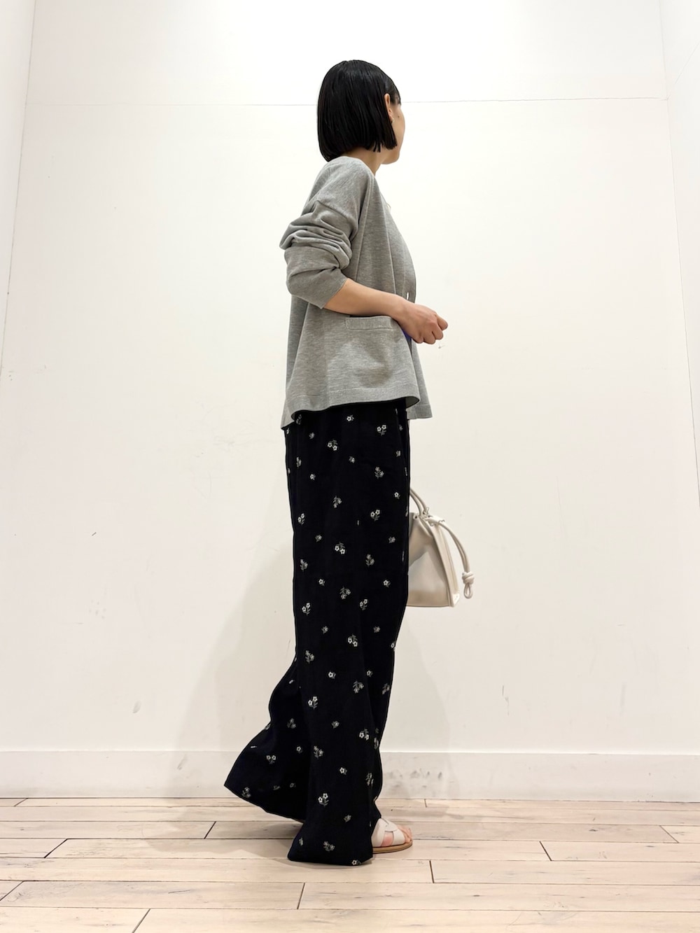 ホワイト系のタンクトップ、グレー系のカーディガン/ボレロ、ホワイト系のトートバッグを着用したレディースの春コーディネートの5枚目の写真