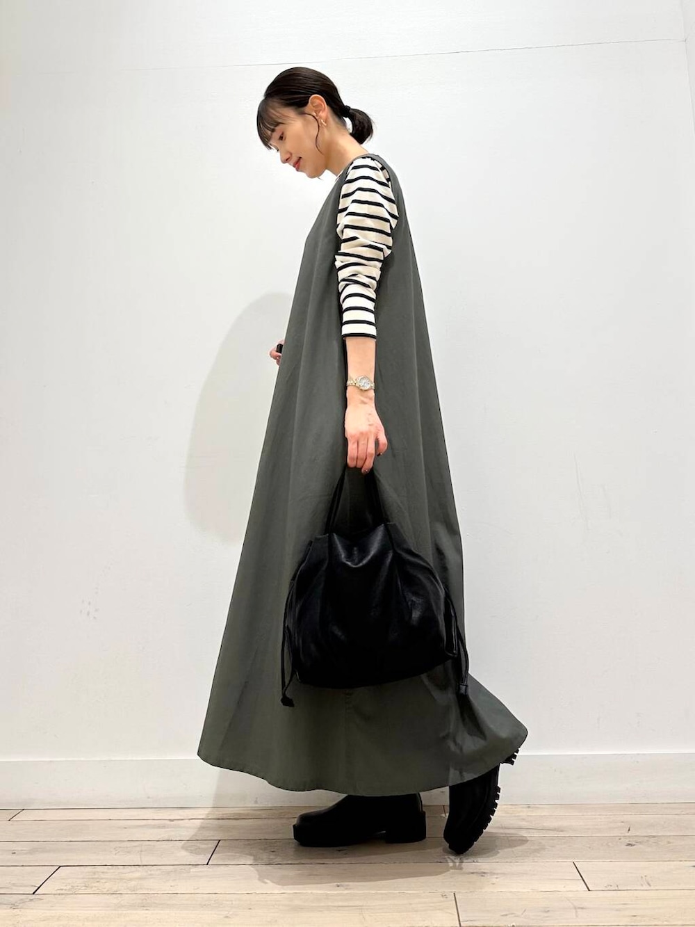 ブラック系のショルダーバッグ、ブルー系のTシャツ/カットソー、グリーン系のワンピースを着用したレディースの秋コーディネートの3枚目の写真