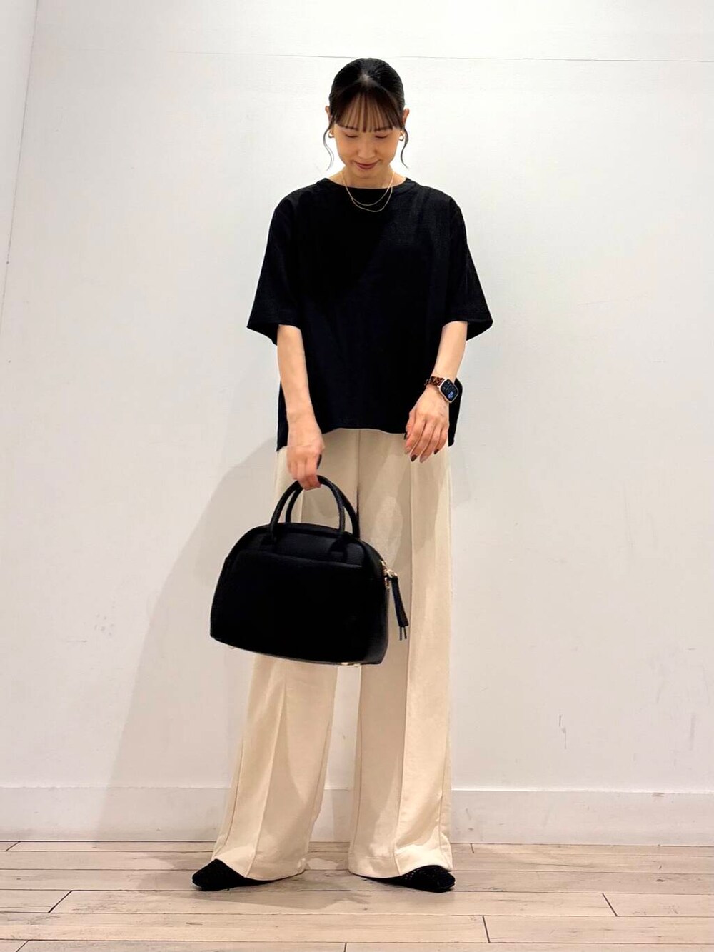 ブラック系のボストンバッグ、ブラック系のバレエシューズ、ブラック系のシャツ/ブラウスを着用したレディースの夏コーディネートの3枚目の写真