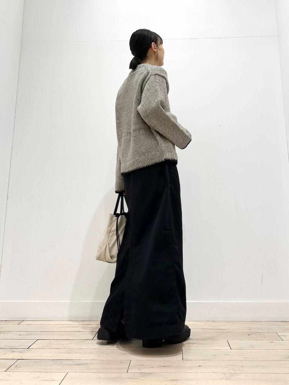 ホワイト系のショルダーバッグ、グレー系のニット/セーター、ブラック系のスカートを着用したレディースの冬コーディネートの4枚目の写真