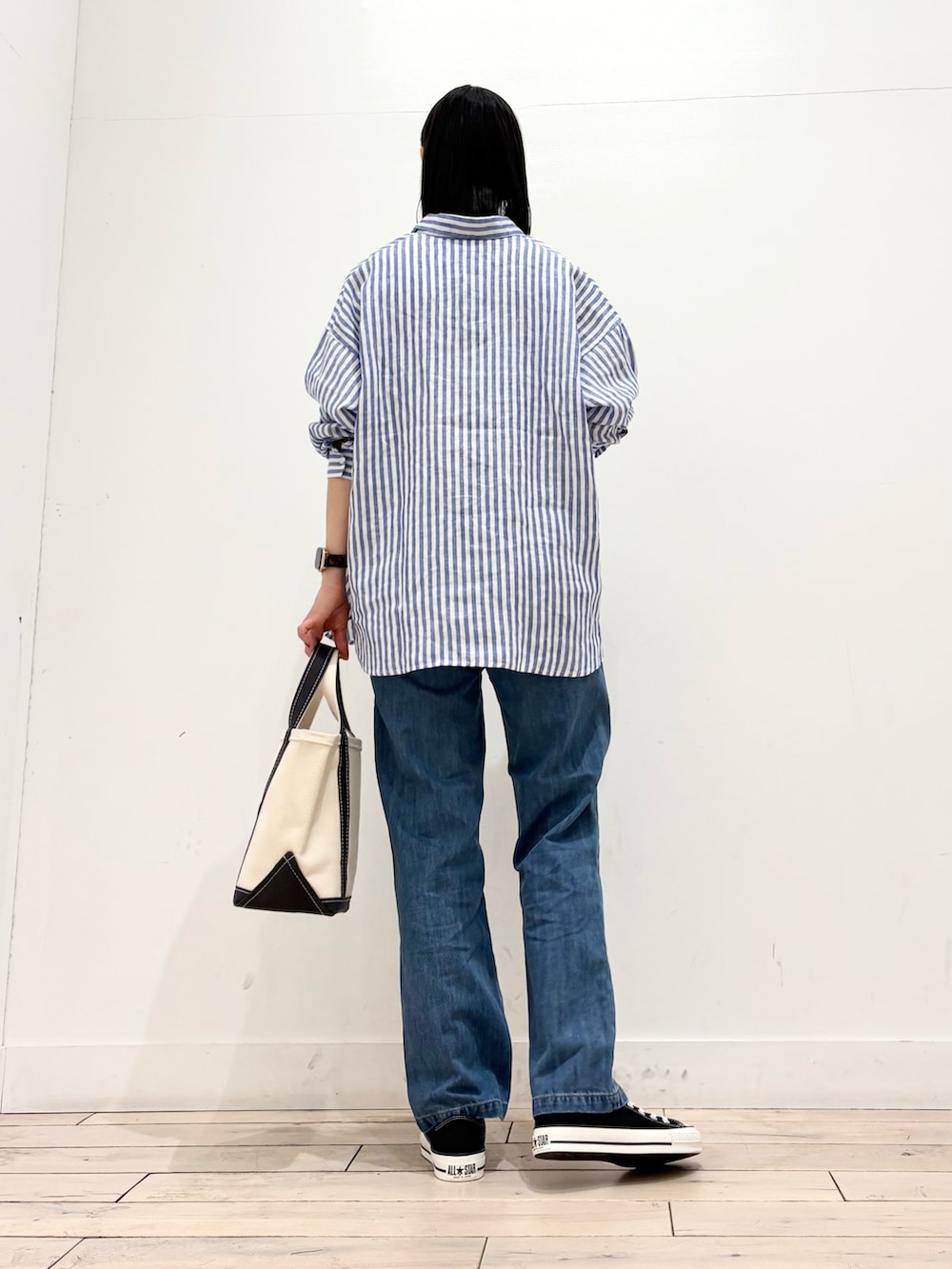 ホワイト系のタンクトップ、グレー系のトートバッグ、ブラック系のスニーカーを着用したレディースの春コーディネートの5枚目の写真