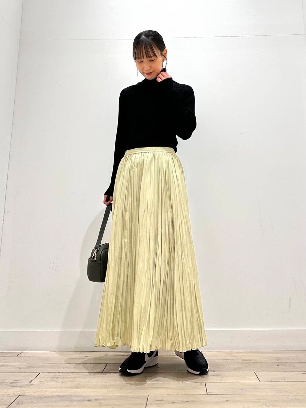 グリーン系のショルダーバッグ、ブラック系のその他アウター、ブラック系のニット/セーターを着用したレディースの冬コーディネートの3枚目の写真