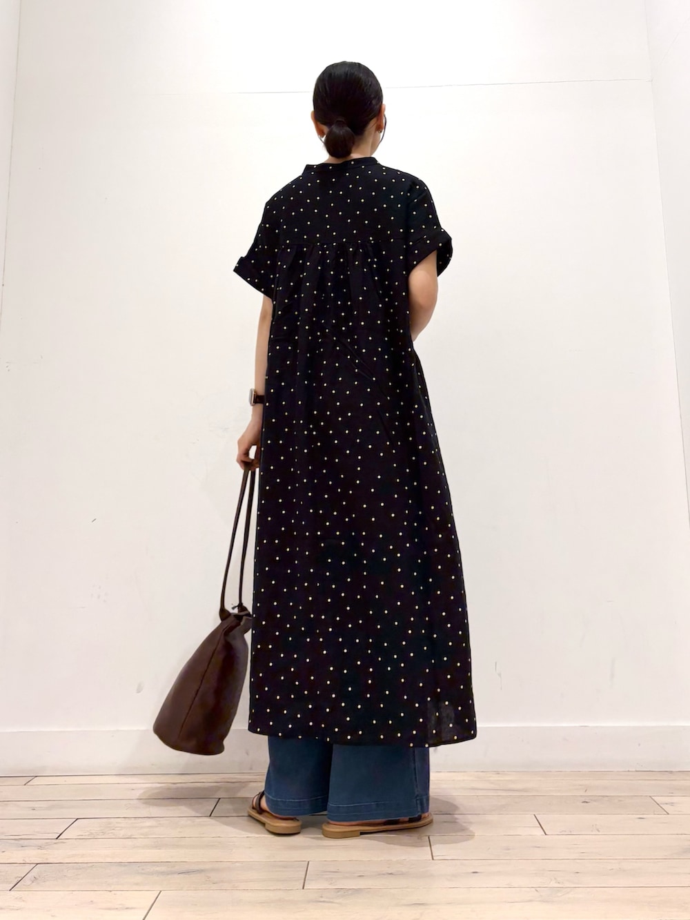 ブルー系のデニムパンツ、ブラウン系のサンダル、ブラック系のワンピースを着用したレディースの夏コーディネートの4枚目の写真